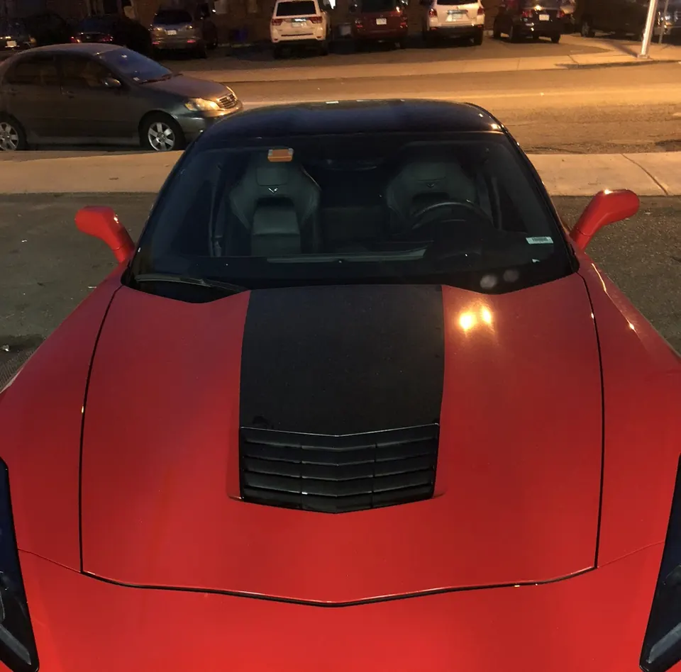 Red Corvette with a black vinyl stripe over the hood