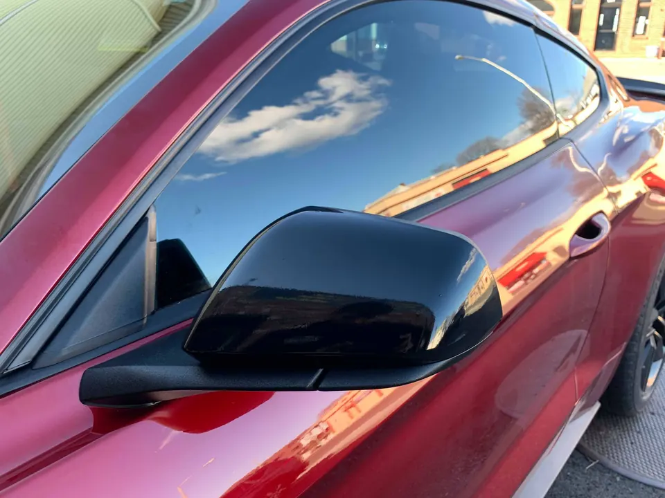 Gloss black mirror cap wrapped on a red Mustang