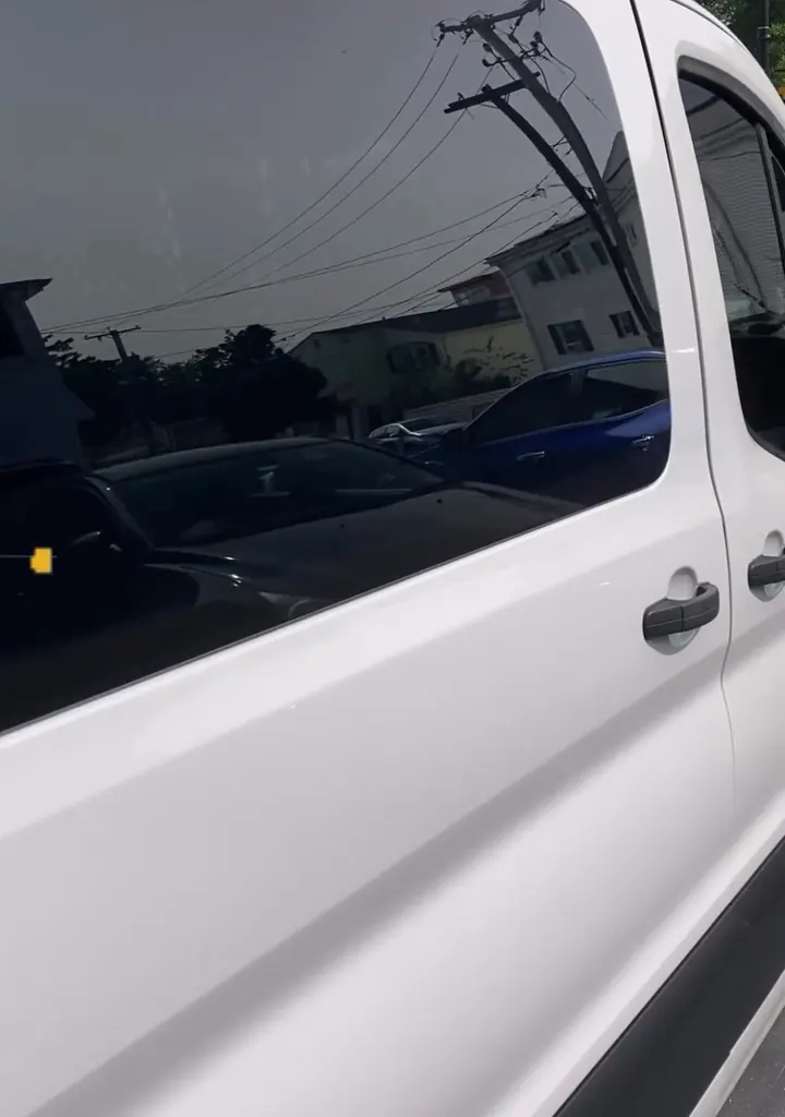 Side of a white van with dark XPEL tint on the rear windows