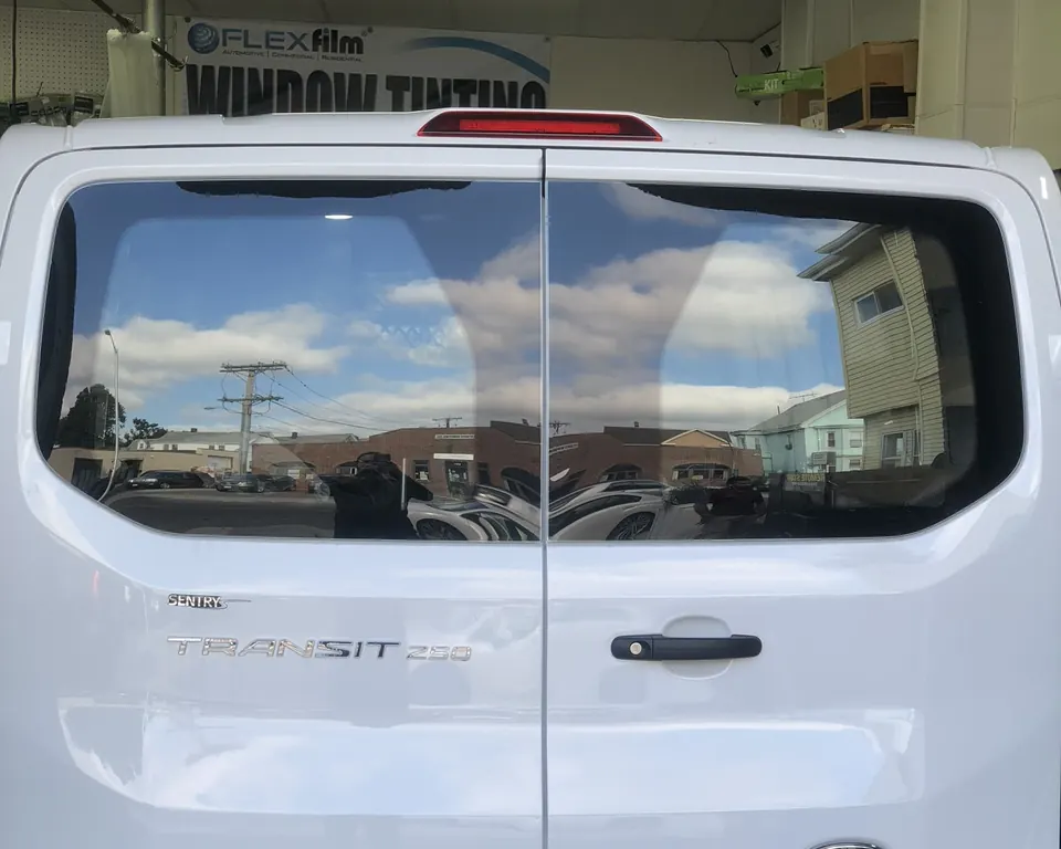 White Ford Transit van with tinted rear windows, in the shop